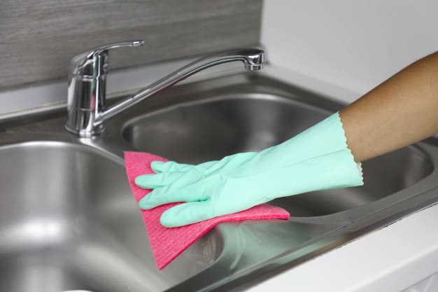 hands protective gloves with rag wiping sink maid housewife cleans house general cleaning regular wash up 63239 1145